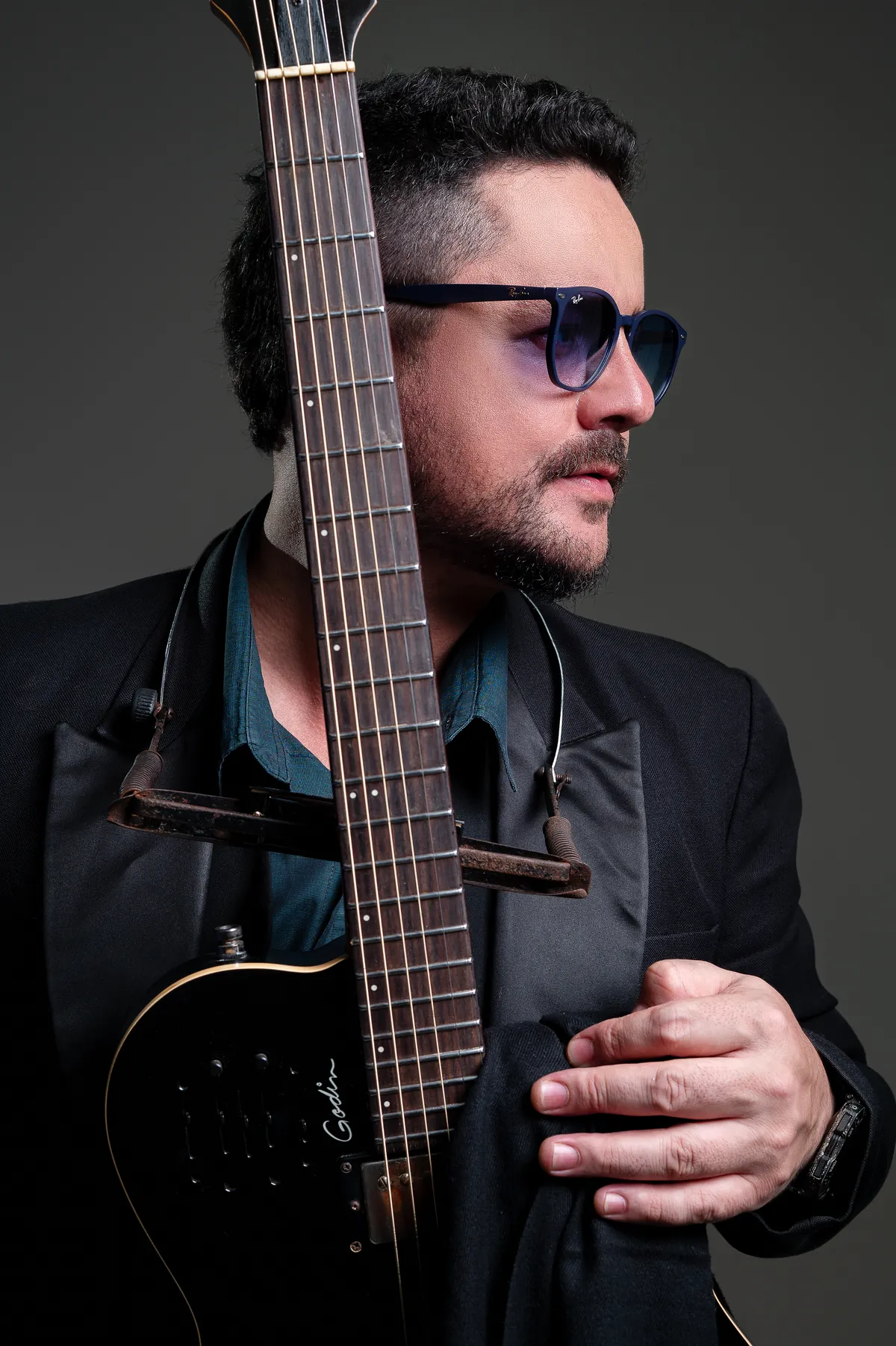 Braço da guitarra cruzando o rosto de Roy