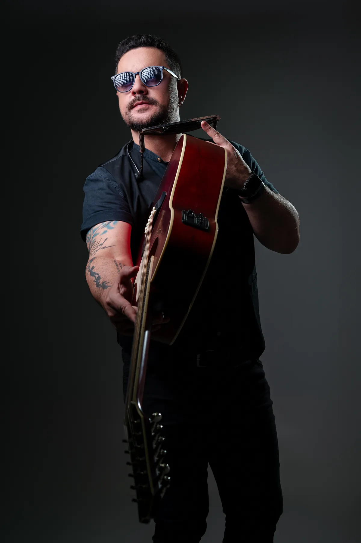 Roy tocando guitarra em plano médio